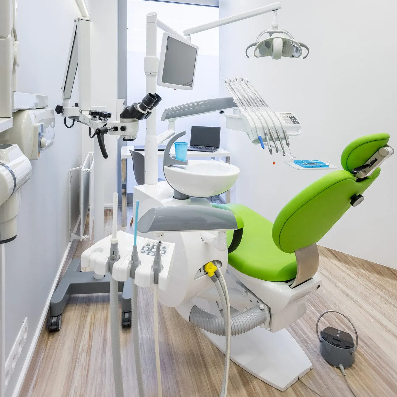 Treatment room at Medical-Dent with the dental chair and operating microscope