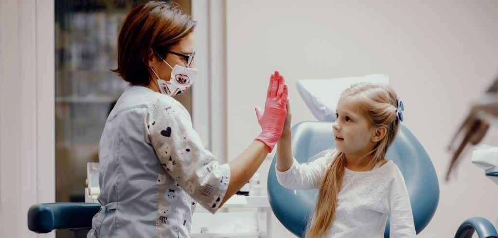 A child giving a dental professional a high five