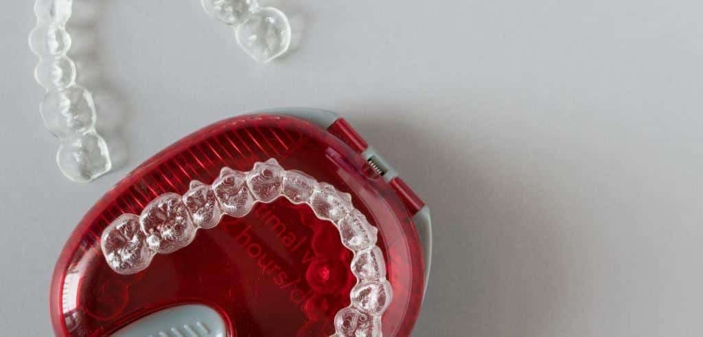 Clear dental trays with a red storage case