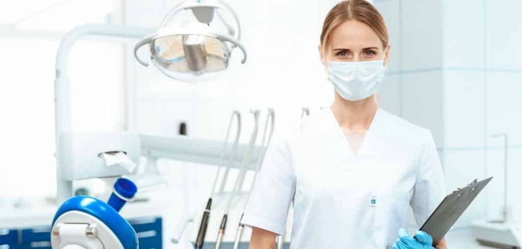 A dental professional holding a clipboard in a surgery