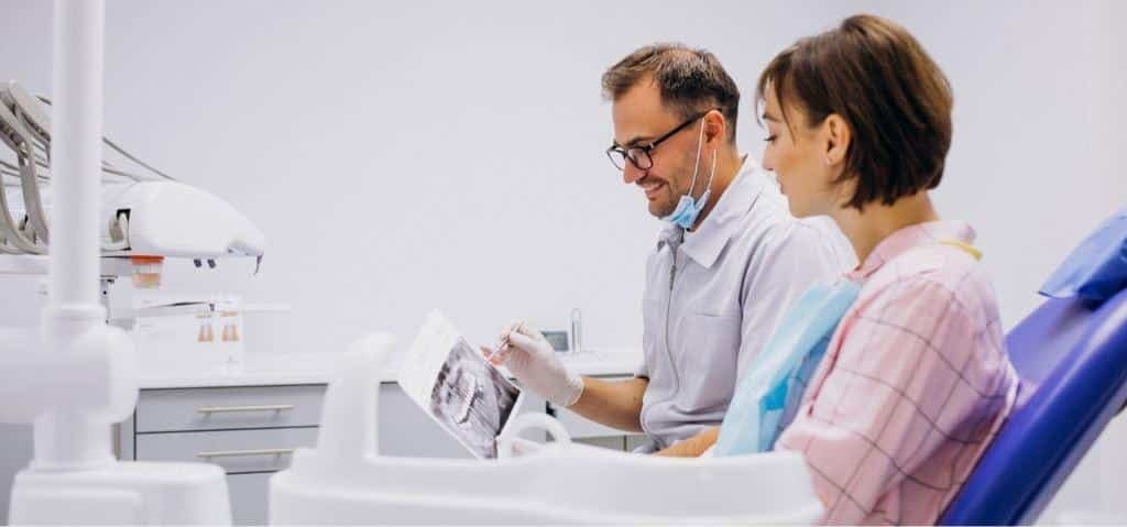 A clinician and patient looking at a dental image together