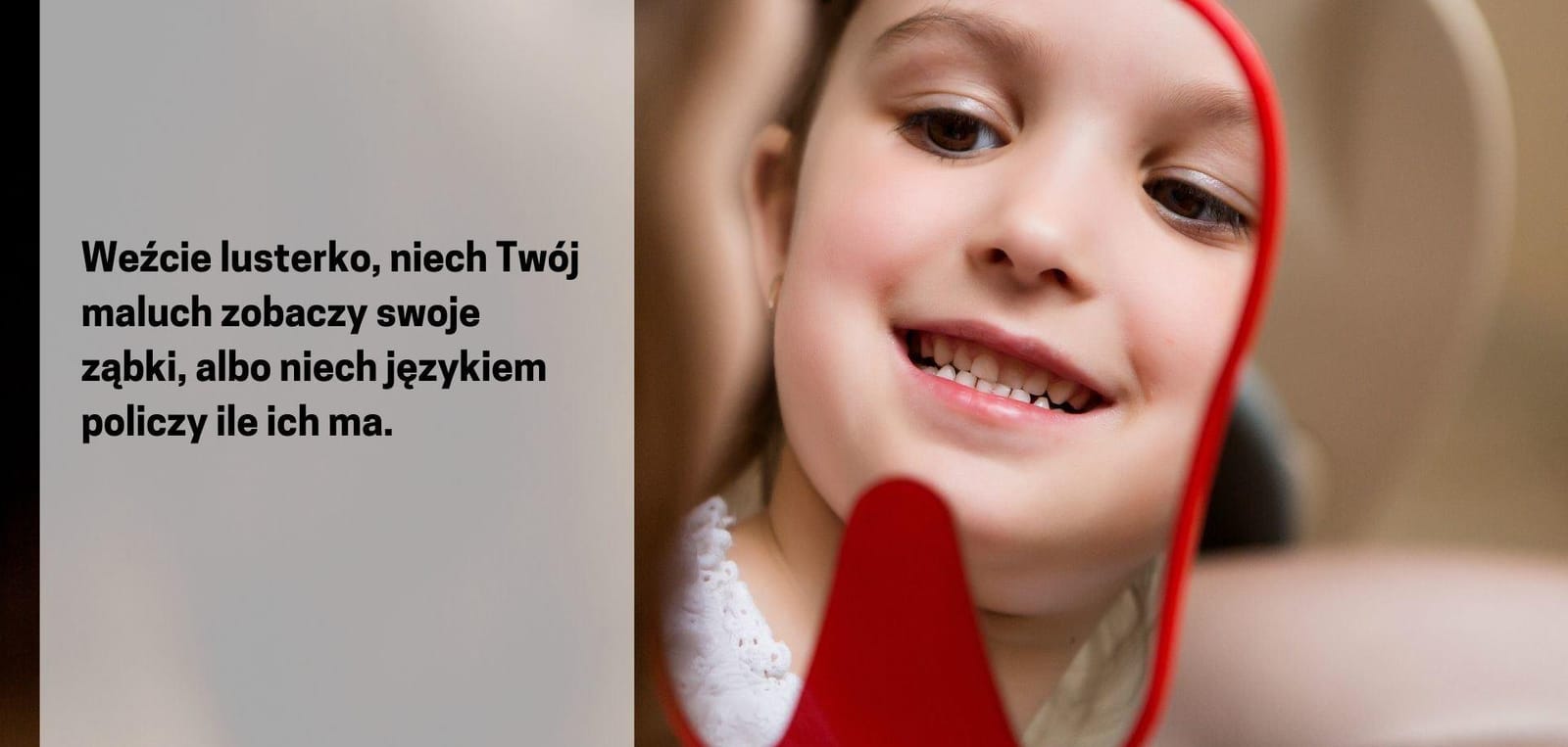 Child looking at their teeth in a hand mirror