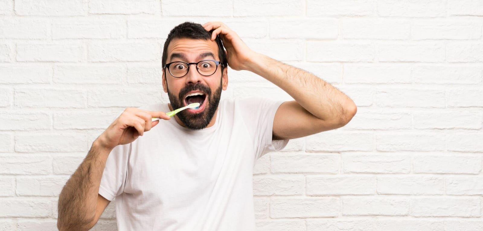 A man holding a toothbrush with a surprised expression