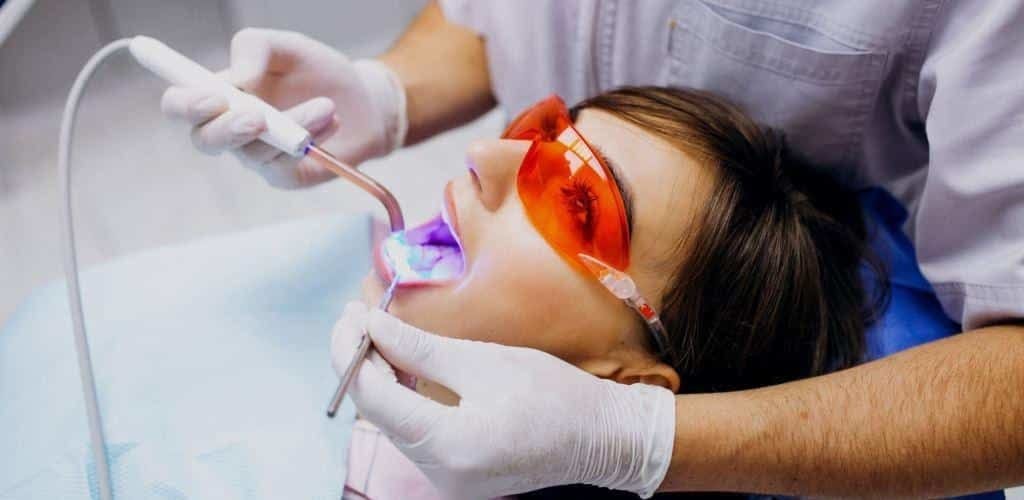 A patient wearing orange protective glasses during dental treatment