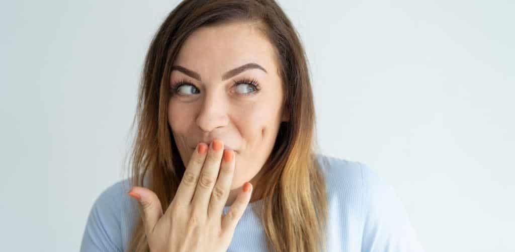 A woman holding her hand near her mouth