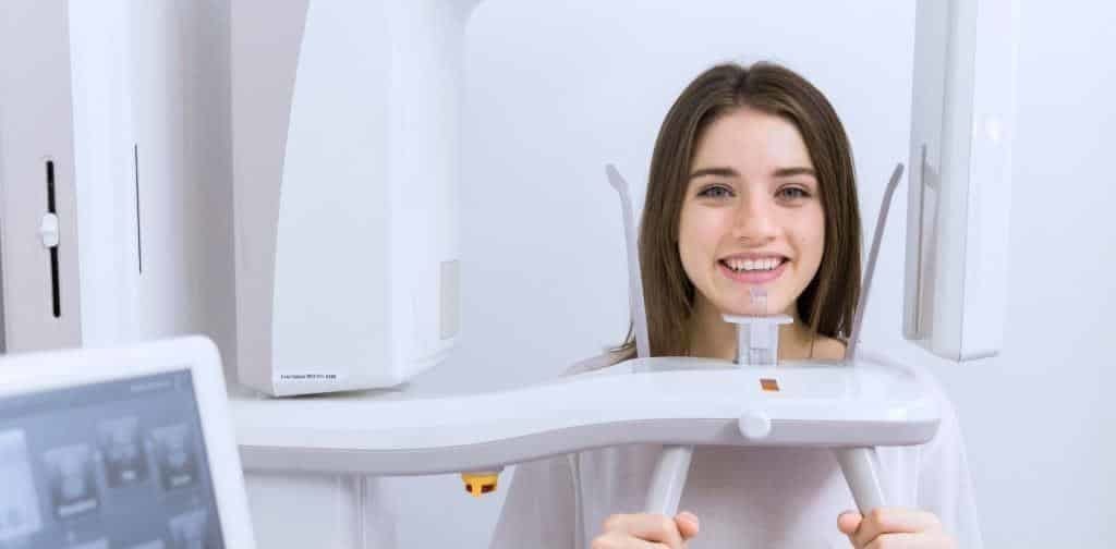 A woman positioned at a dental imaging machine