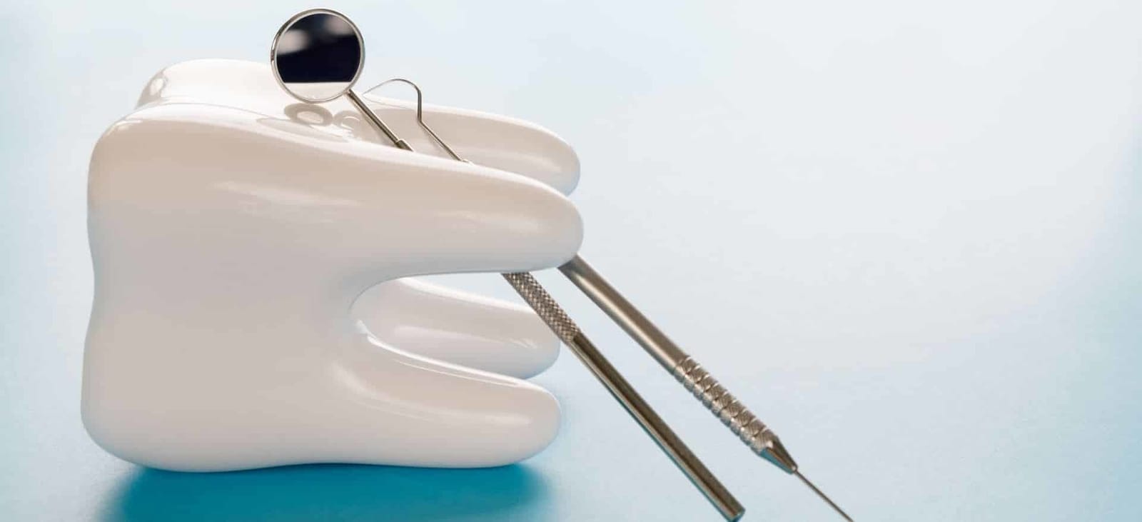 A model tooth holding a dental mirror