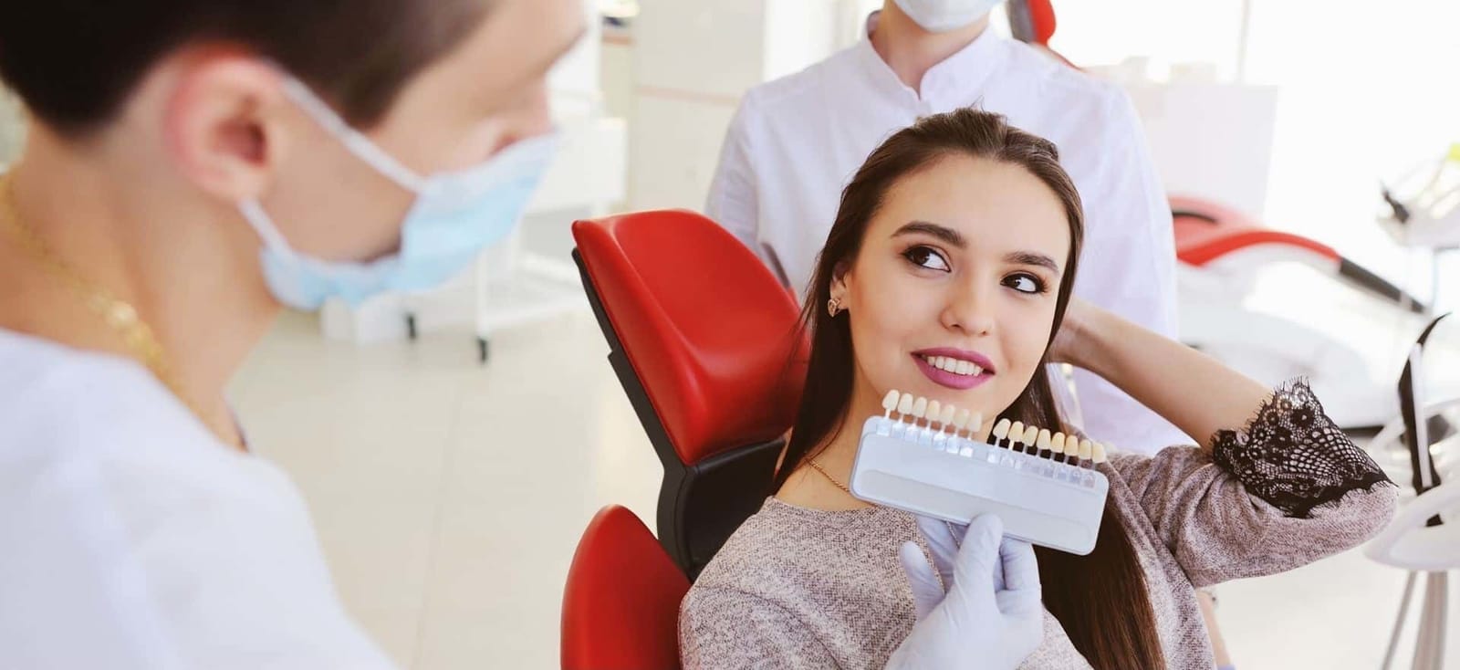 A patient and clinician looking at a tooth shade guide