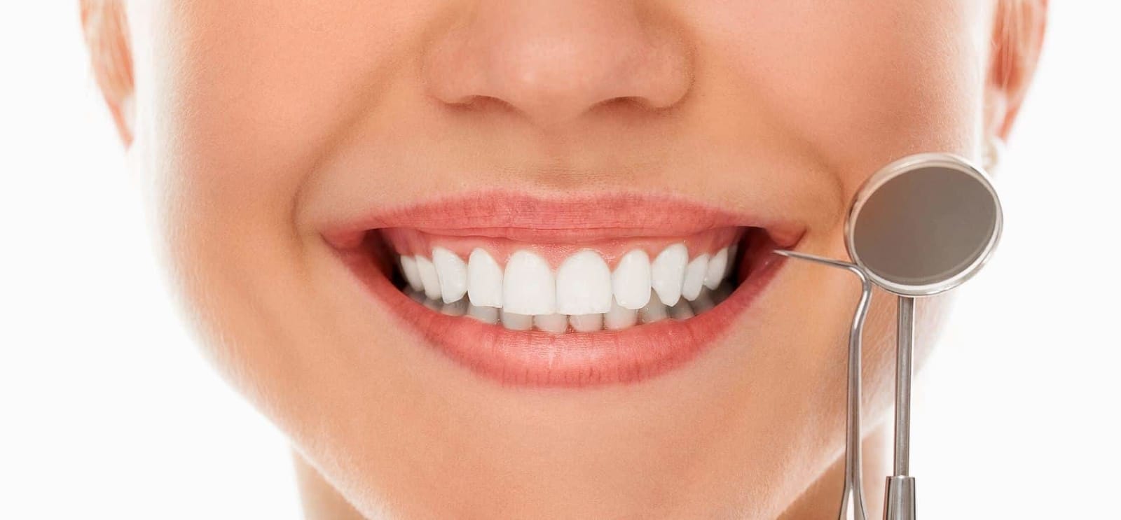 A smiling mouth beside a dental mirror