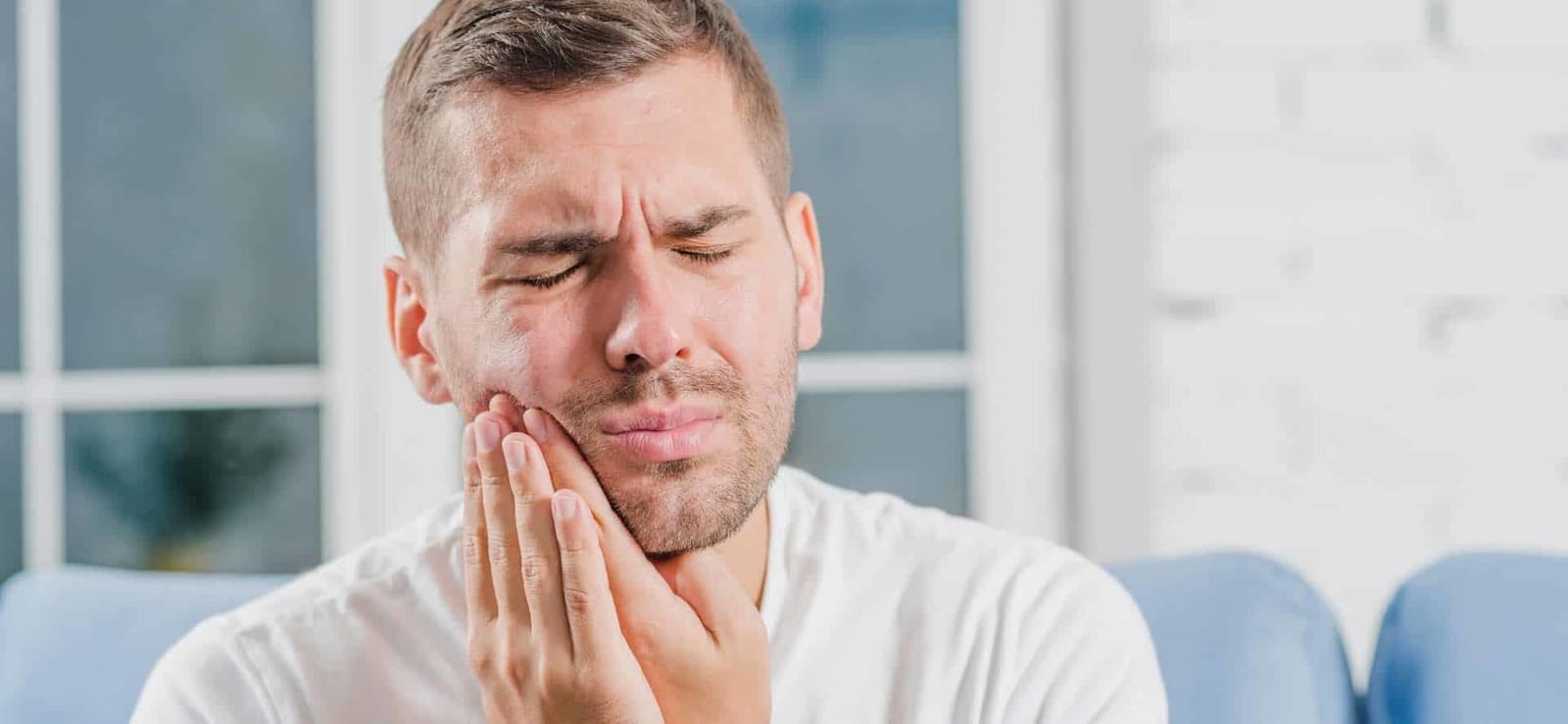 A man holding his cheek