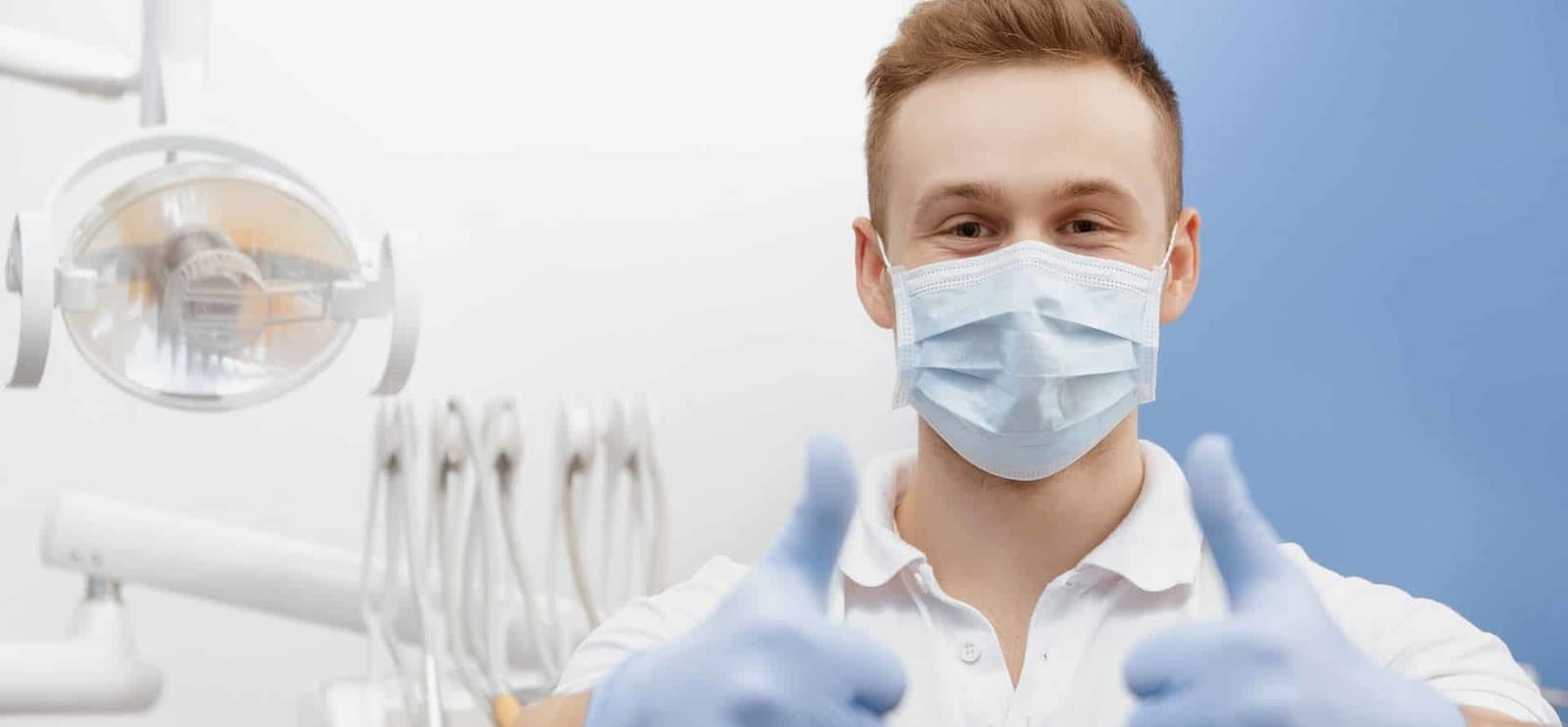 A dentist wearing a mask beside the dental chair