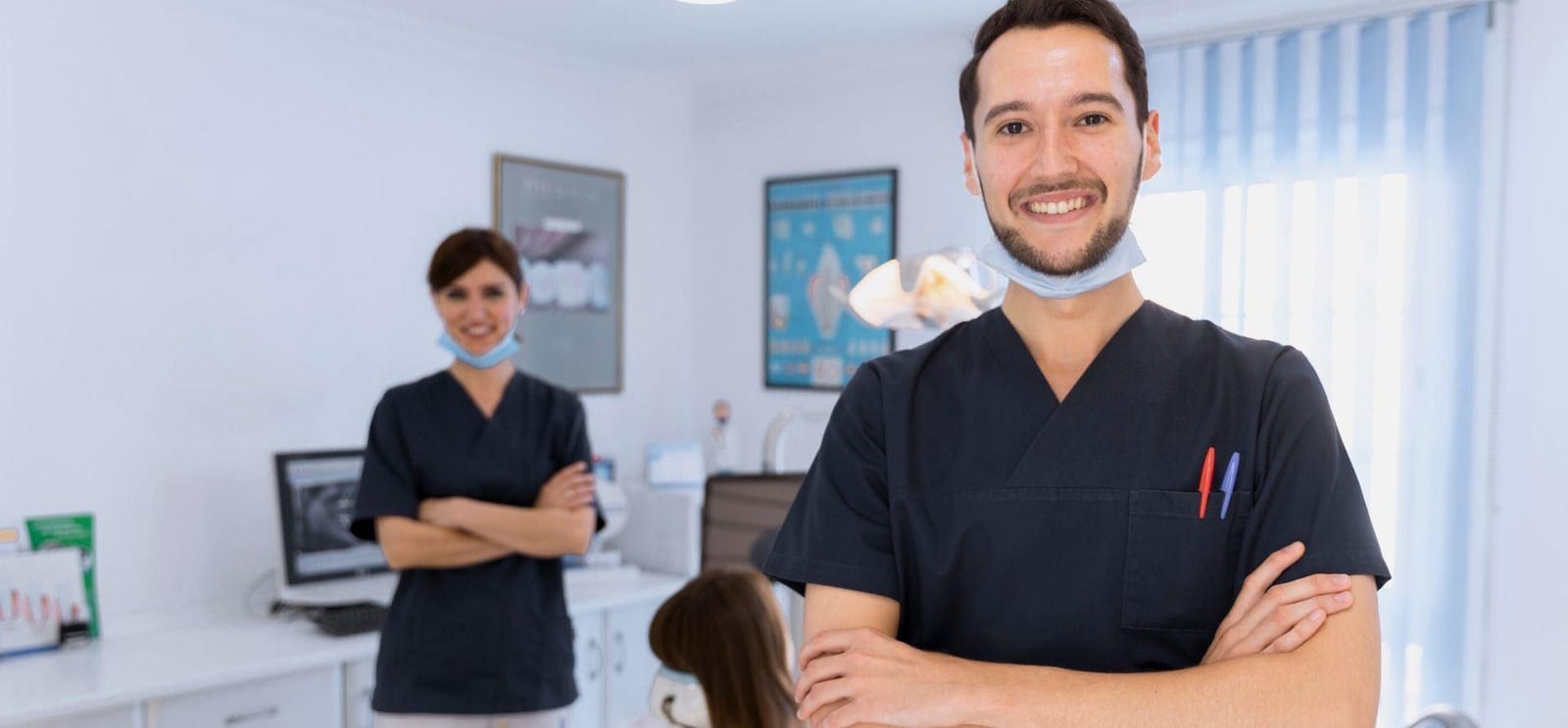 Two members of a dental team in a treatment room
