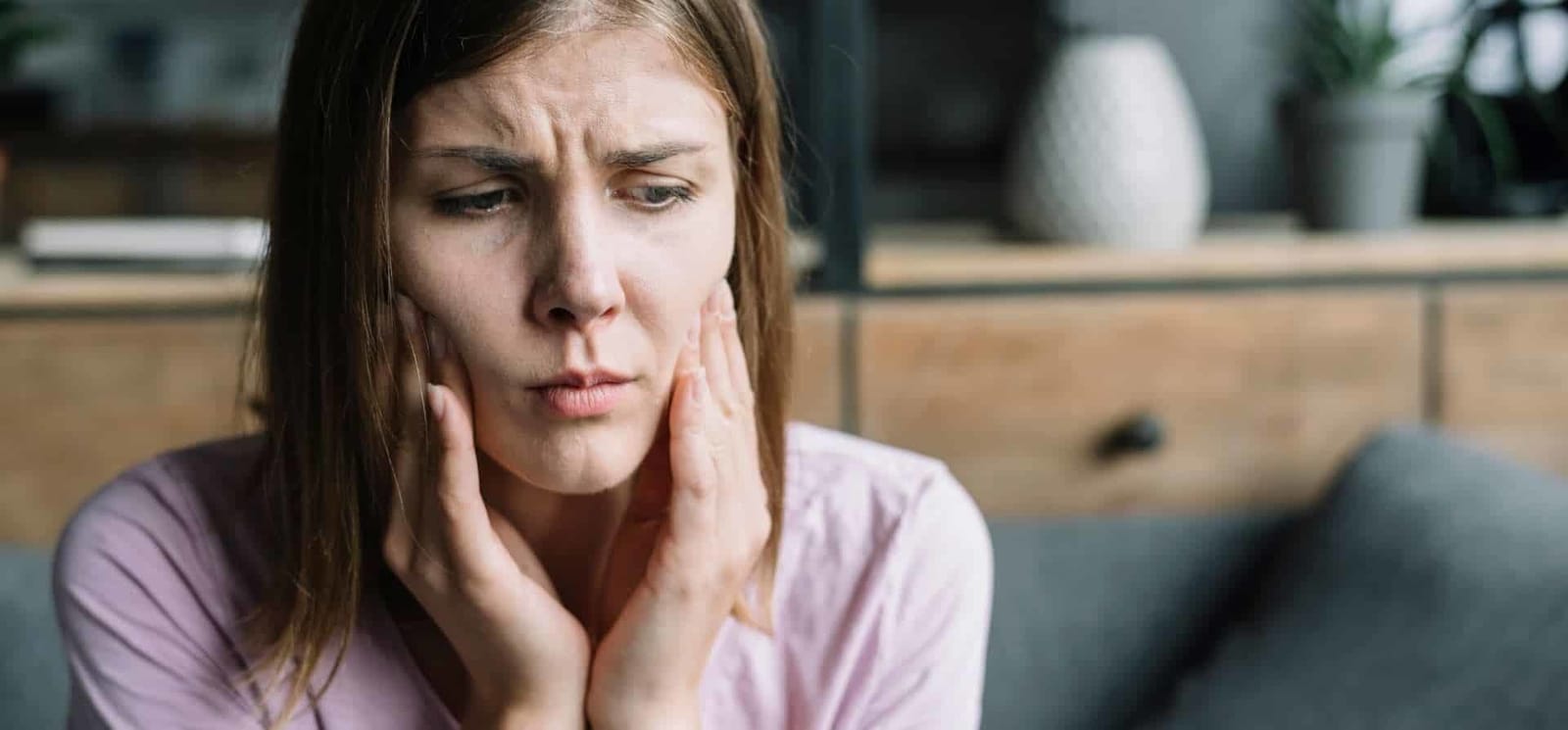 A woman holding both cheeks
