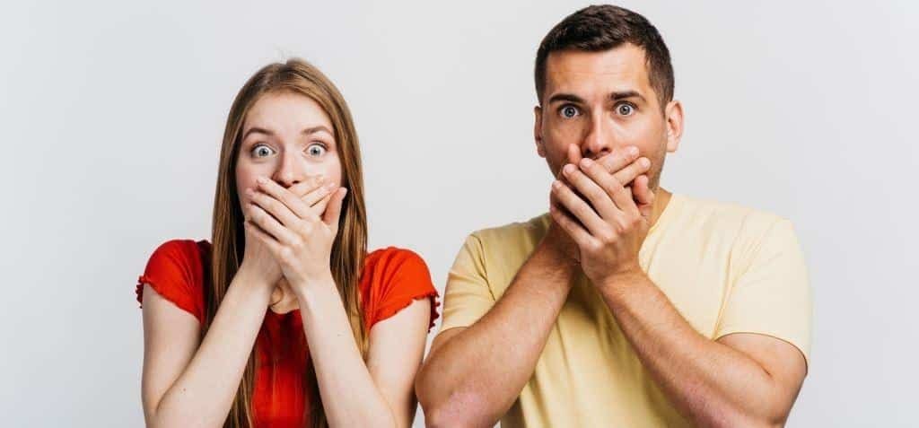 Two people covering their mouths with their hands