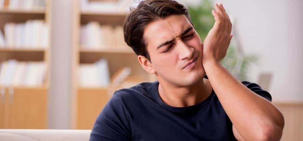 A person holding the side of their face