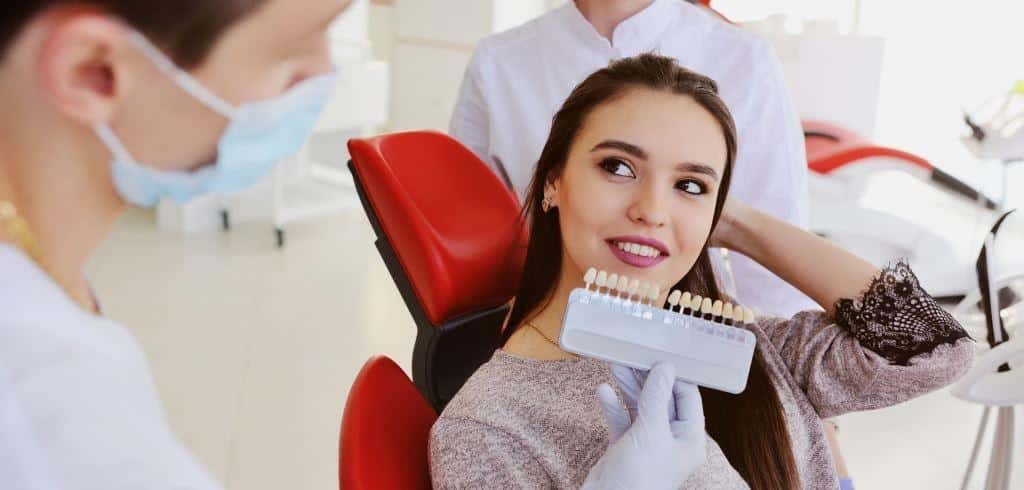 Patient and dental professional comparing tooth shades