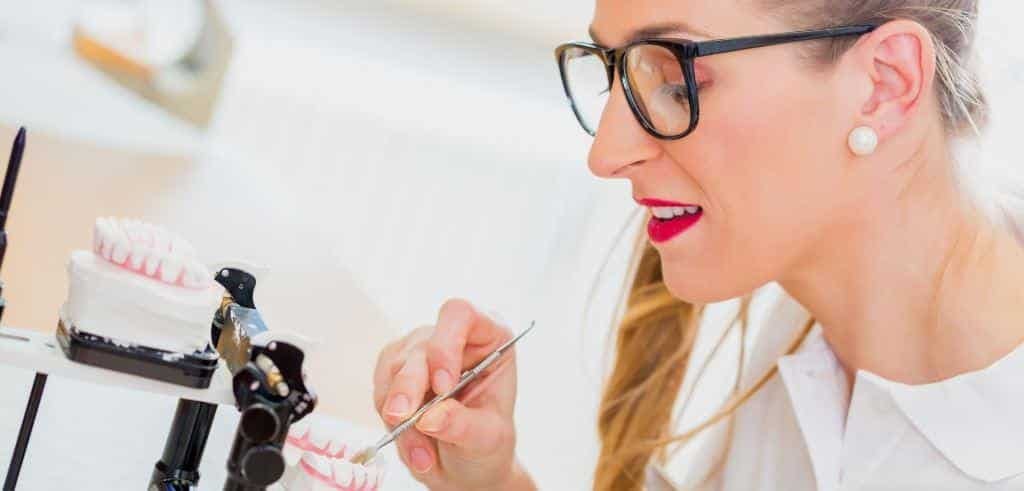 Person working on a dental model in an articulator