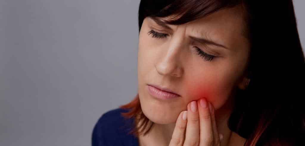 A woman holding her cheek
