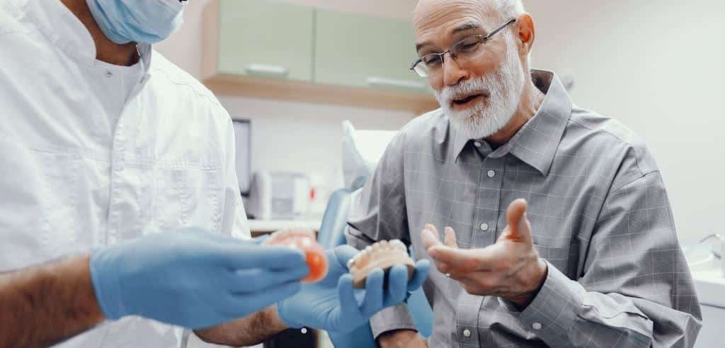 A patient discussing a dental model with a clinician