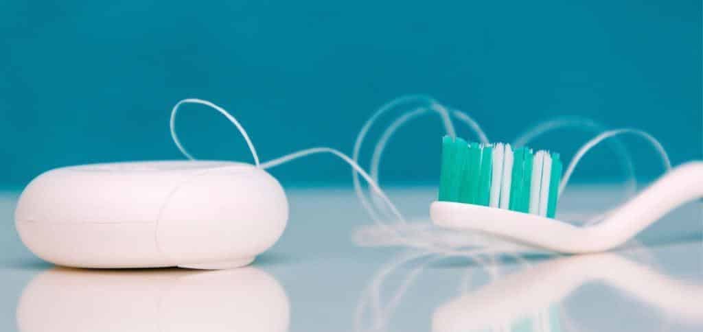 A toothbrush and a container of dental floss