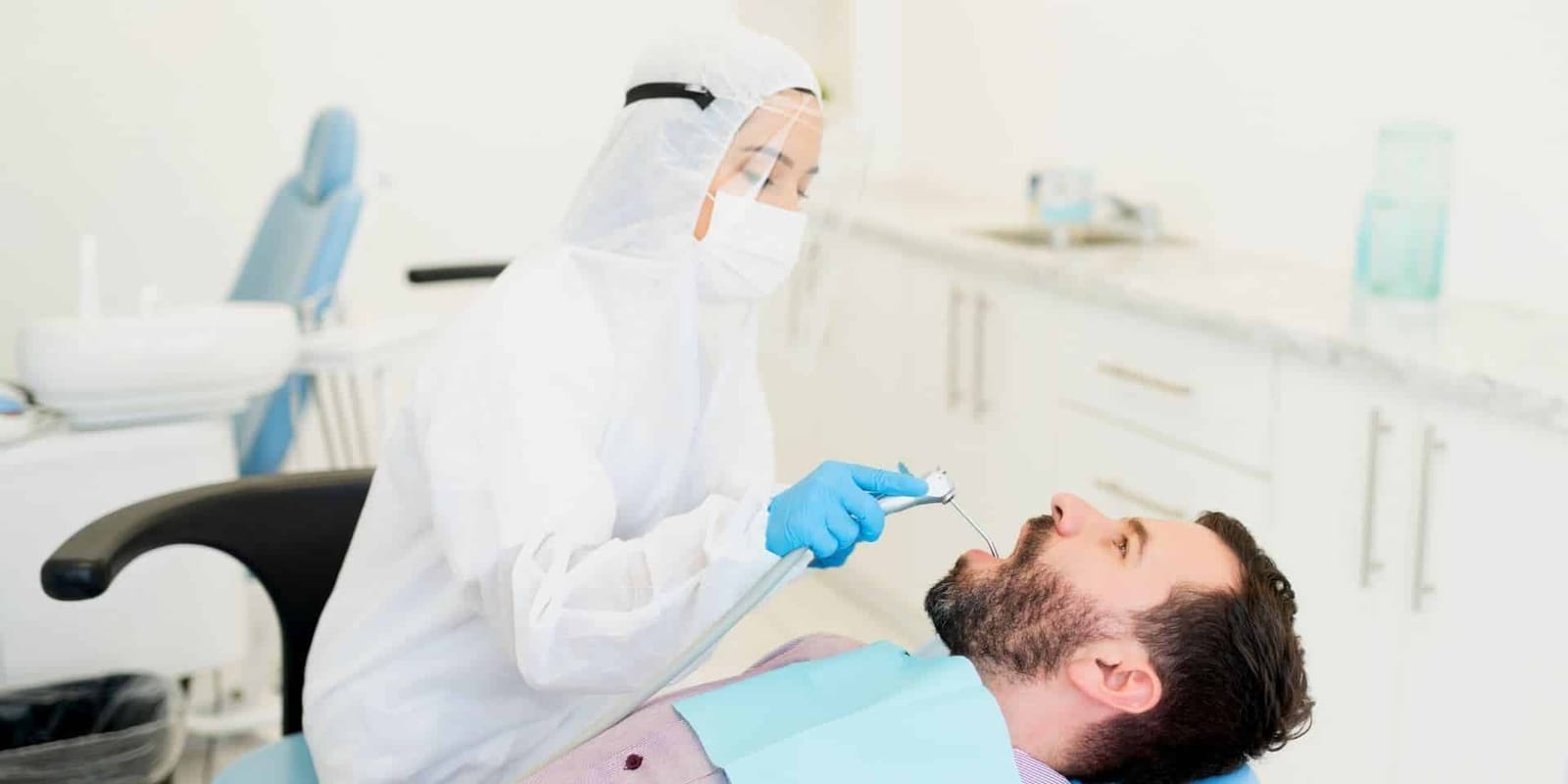 A clinician examining a patient in a dental chair