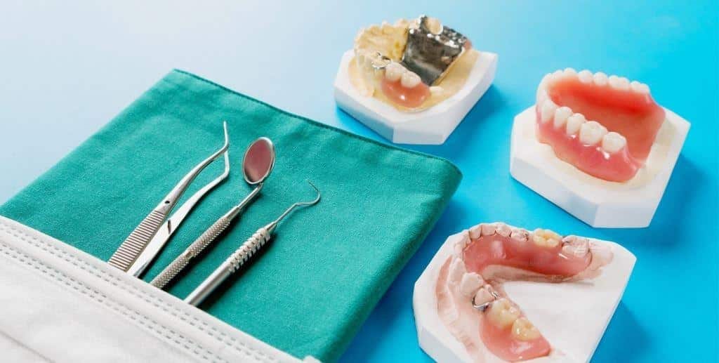 Dental models and instruments arranged on a blue surface