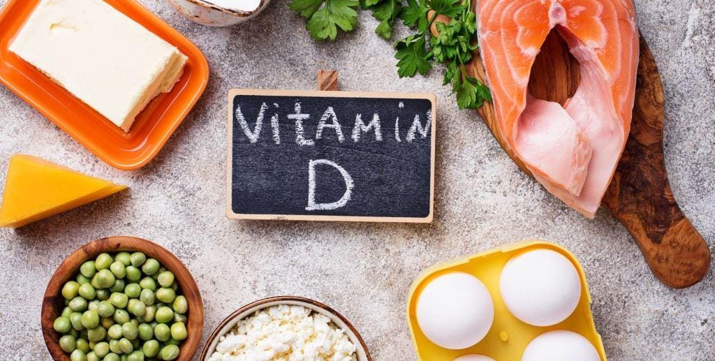 Foods arranged around a small board labelled vitamin D