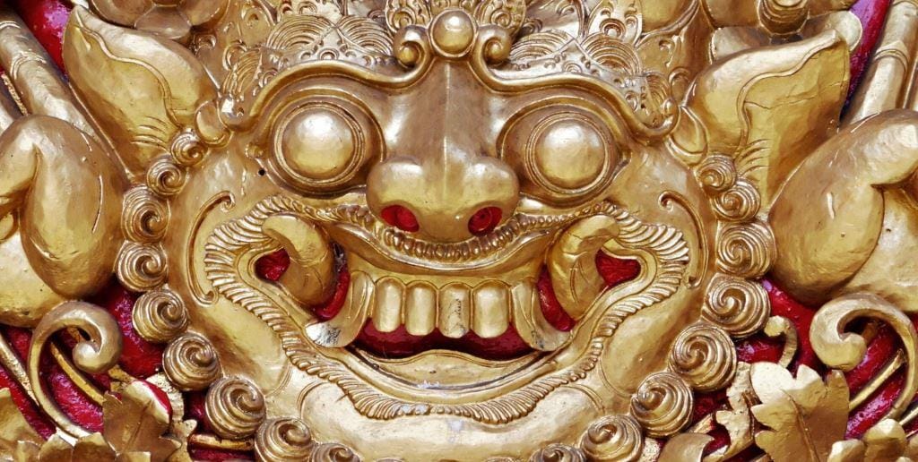 A gold-coloured decorative mask showing the mouth and teeth