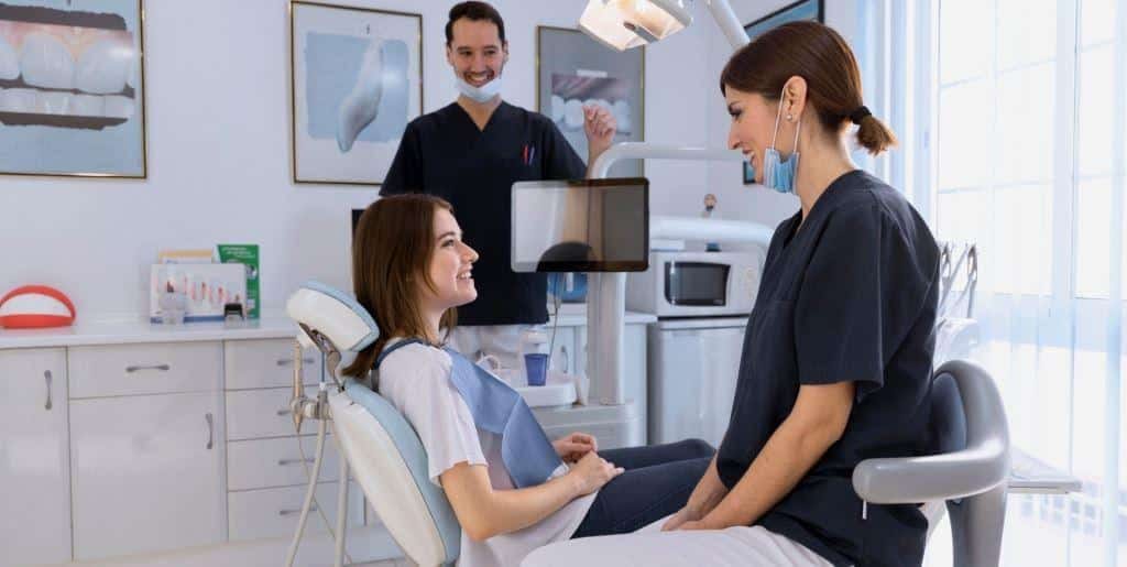 A patient talking with the dental team beside the dental chair