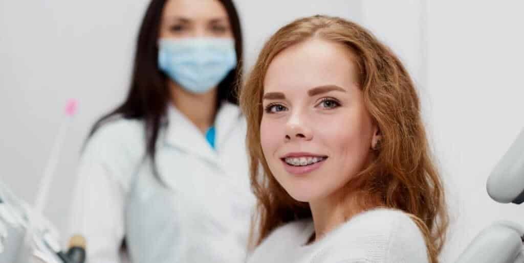 A patient with braces seated in a dental surgery