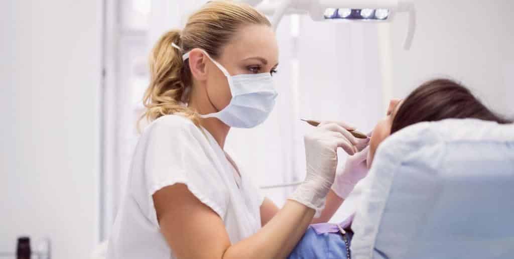 A clinician examining a patient’s mouth