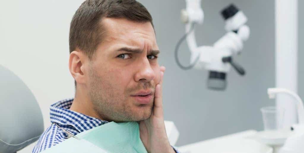 A person holding a hand against their cheek