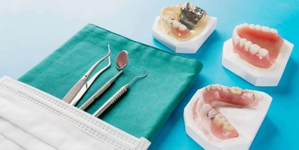 Denture models and dental instruments on a green cloth