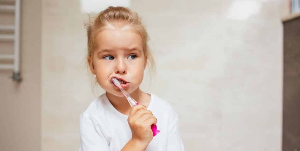 A child using a manual toothbrush.