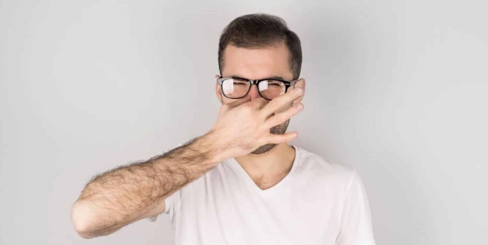 A man covering his nose and mouth with his hand