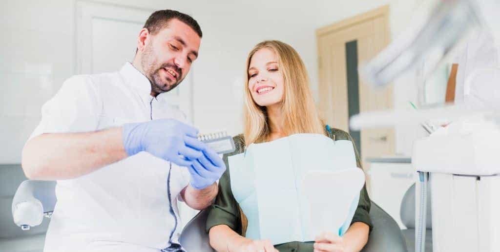A clinician and patient looking at a tooth shade guide