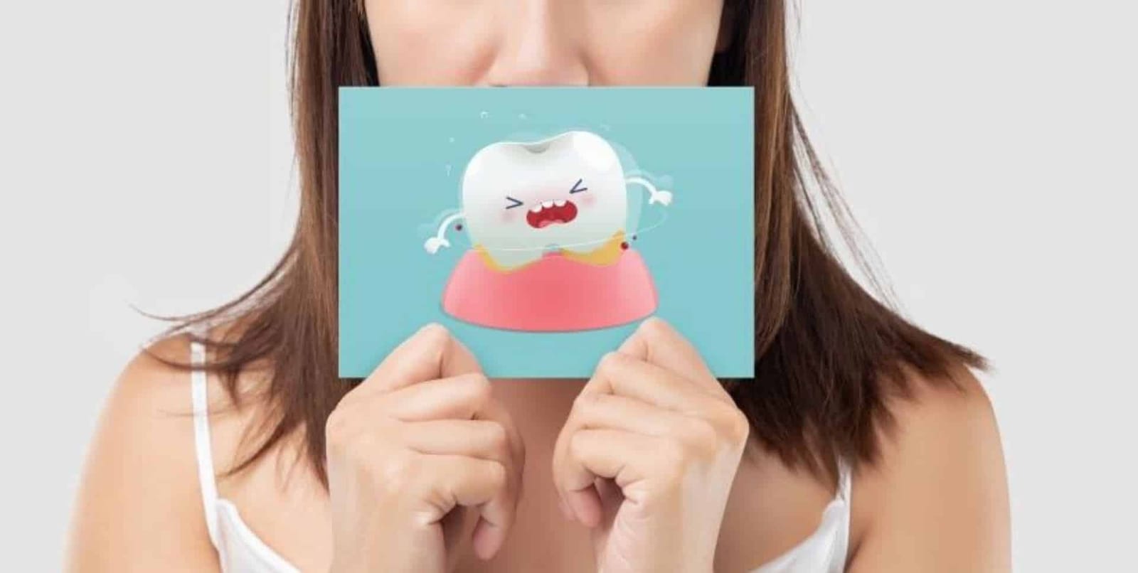A person holding a card with a cartoon tooth
