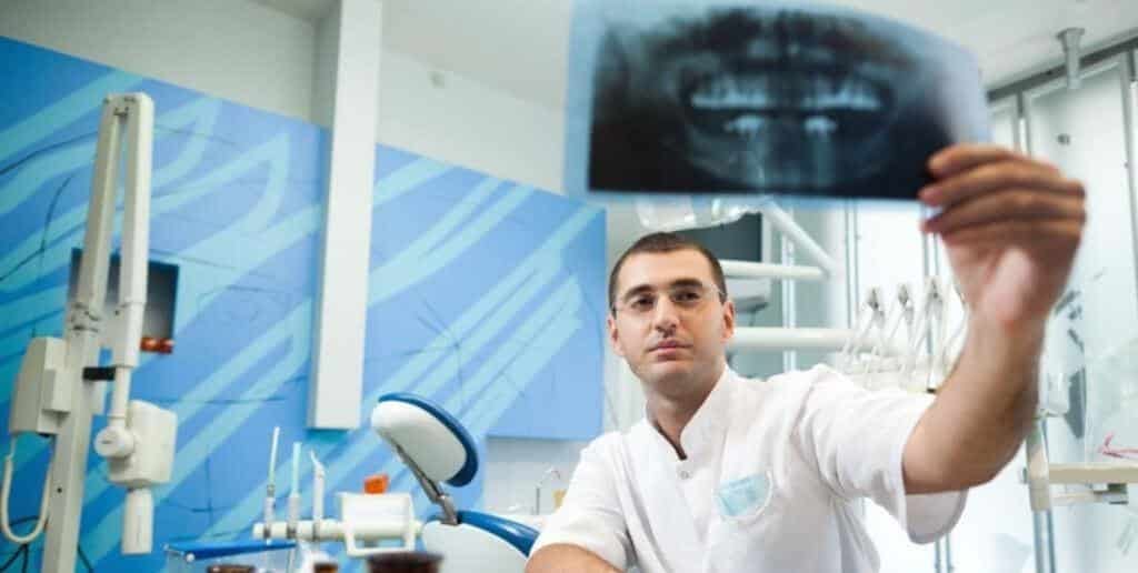 A clinician looking at a panoramic dental X-ray