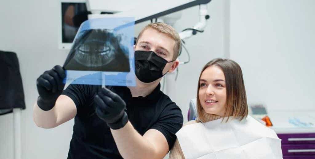A dentist showing a panoramic dental X-ray to a patient
