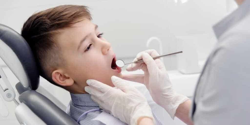 A child having their teeth examined with a dental mirror