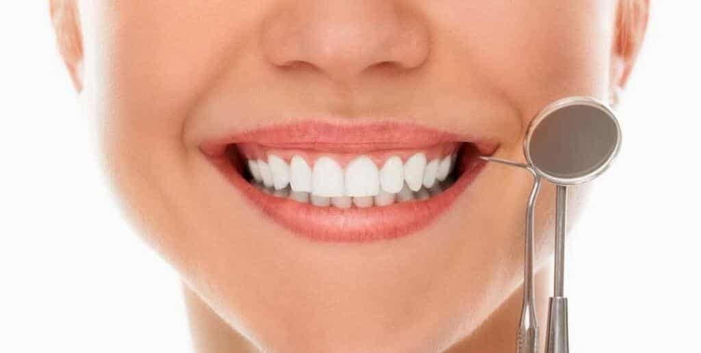 A smiling mouth beside a dental mirror
