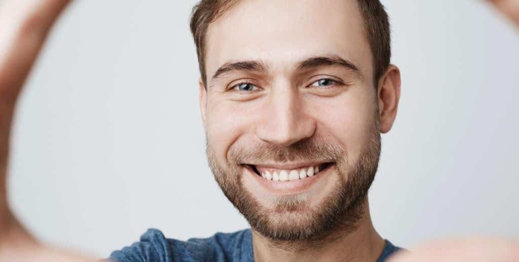 A smiling man in a blue T-shirt