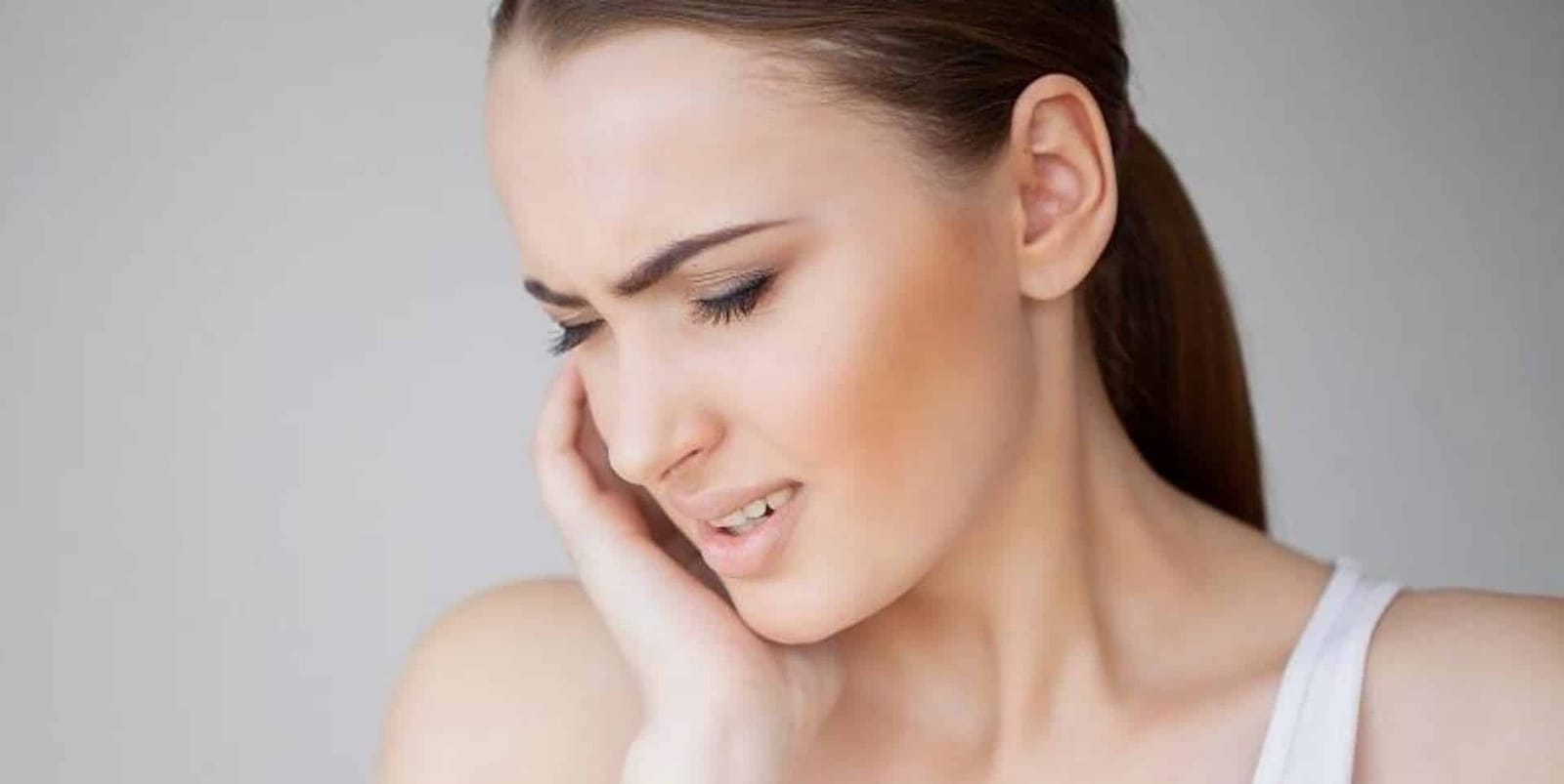A woman holding her cheek