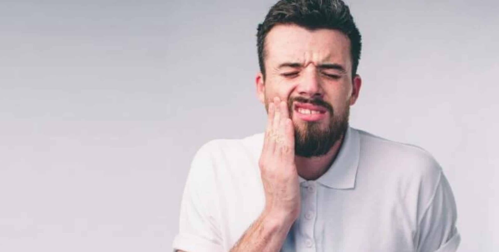 A man holding his cheek