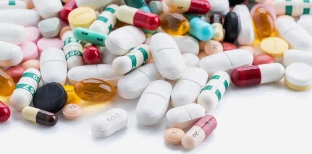 Assorted tablets and capsules on a white surface