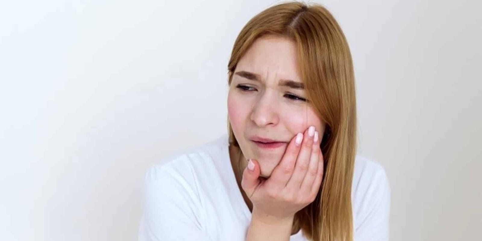 A woman holding her cheek