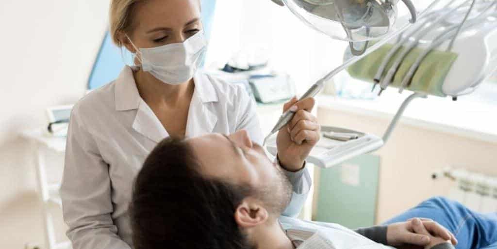 A dentist examining a patient in a dental chair