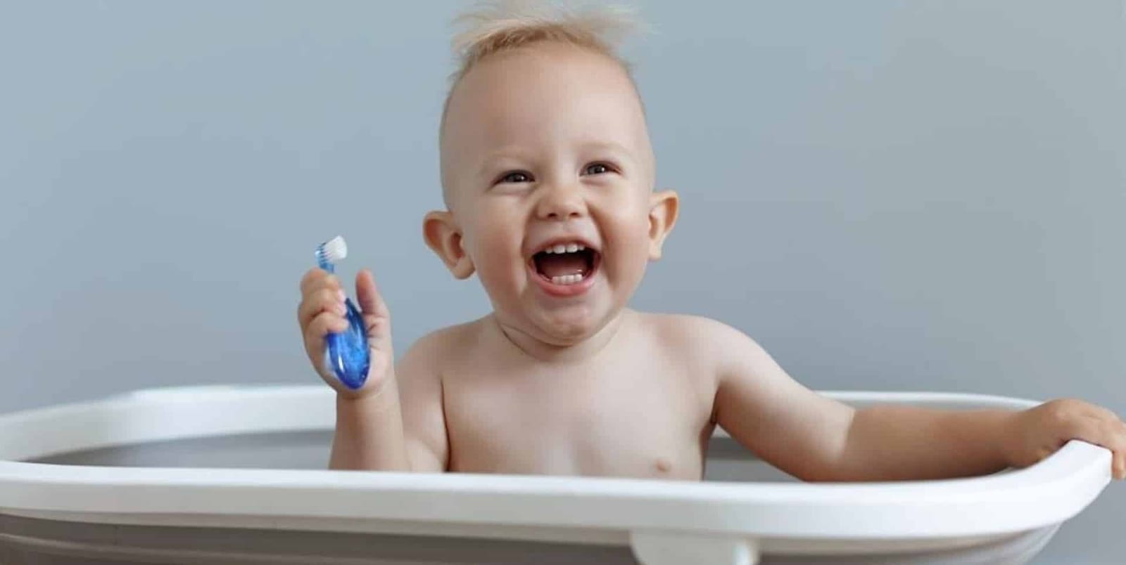 A baby holding a small toothbrush