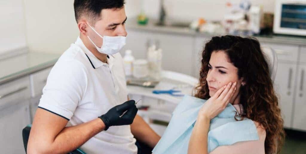 A clinician speaking to a patient who is holding her cheek