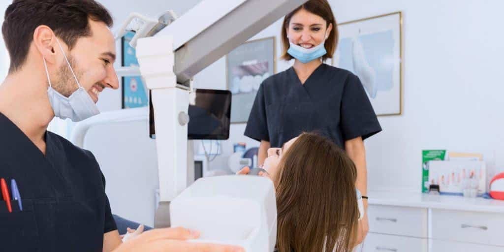 Dental team speaking with a seated patient